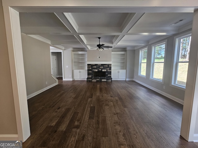 unfurnished living room with coffered ceiling, a stone fireplace, dark hardwood / wood-style floors, beamed ceiling, and ceiling fan