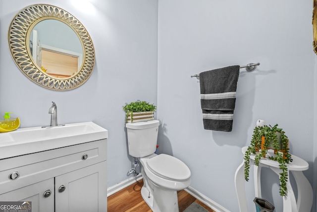 bathroom featuring hardwood / wood-style flooring, vanity, and toilet