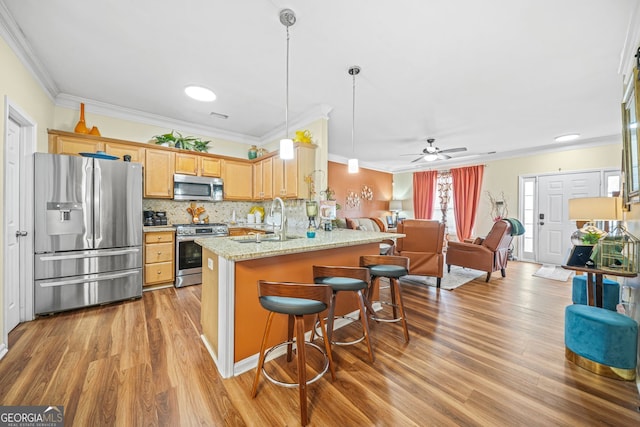 kitchen with decorative light fixtures, decorative backsplash, light stone counters, kitchen peninsula, and stainless steel appliances