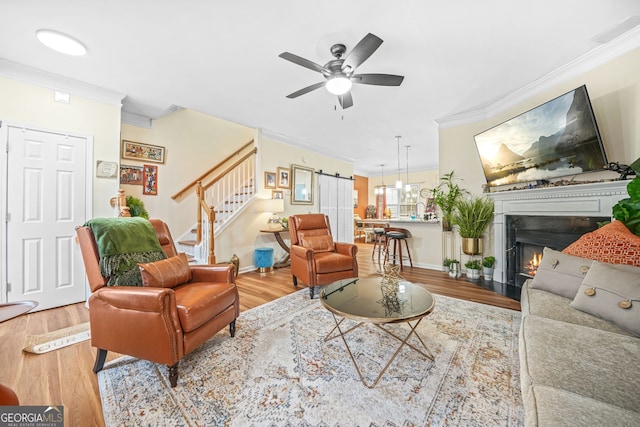 living room with crown molding, ceiling fan, and light hardwood / wood-style flooring