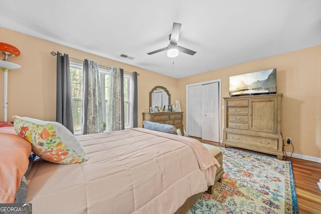 bedroom featuring wood-type flooring, ceiling fan, and a closet