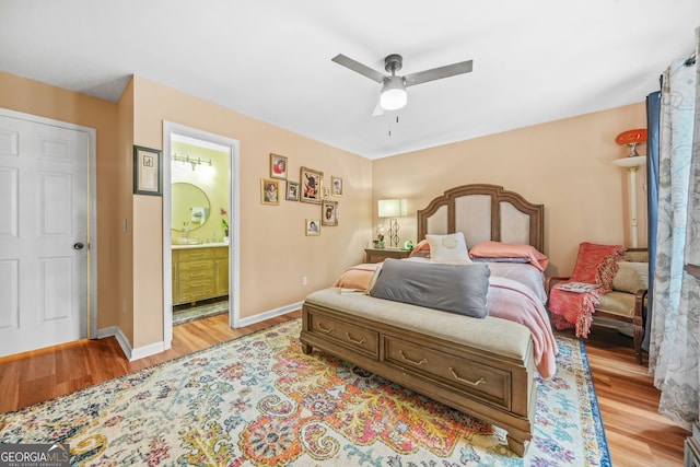 bedroom with ceiling fan, ensuite bath, and light hardwood / wood-style flooring