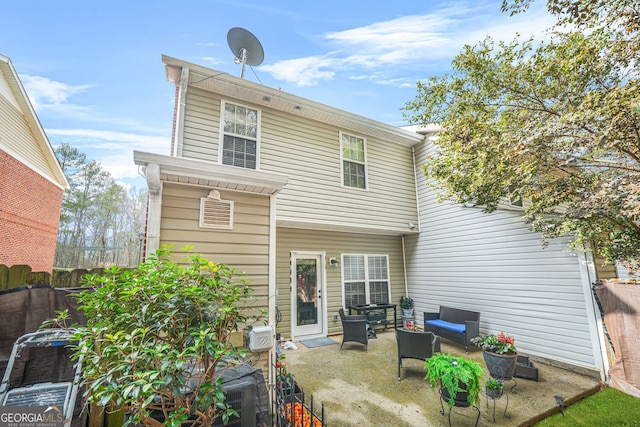 rear view of property with an outdoor living space and a patio