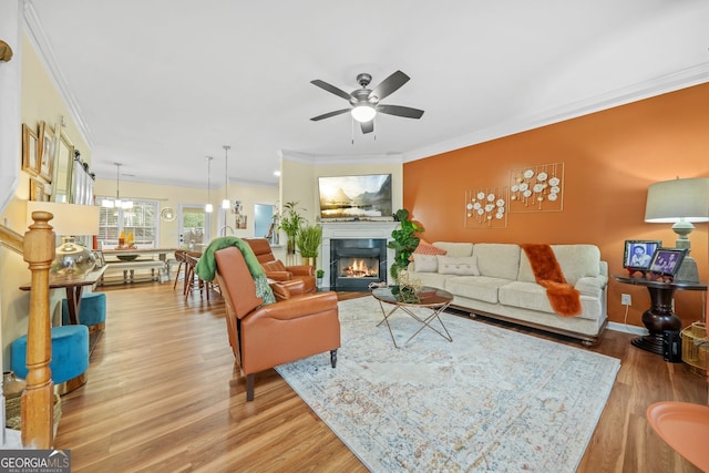 living room featuring ornamental molding, light hardwood / wood-style floors, and ceiling fan