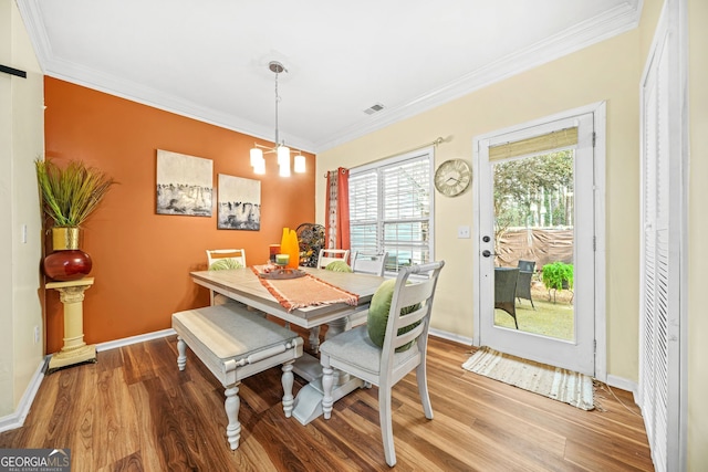 dining area with crown molding and hardwood / wood-style floors