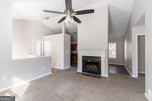 5876 Old Wellborn Trce, Lithonia, GA 30058 - unfurnished living room featuring lofted ceiling, a ceiling fan, carpet, and a fireplace with flush hearth