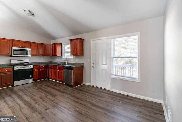 5876 Old Wellborn Trce, Lithonia, GA 30058 - kitchen with appliances with stainless steel finishes, dark countertops, lofted ceiling, and dark wood-style floors