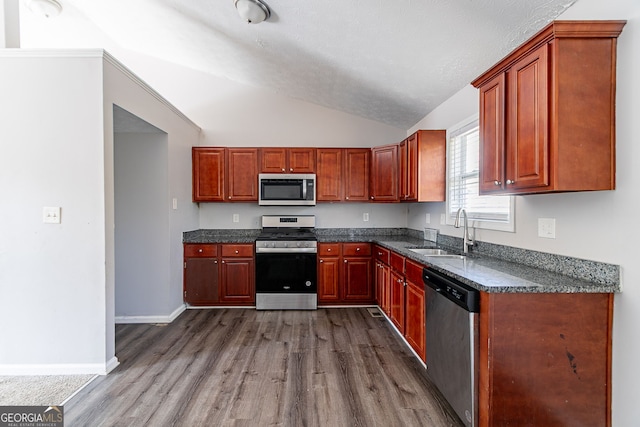 5876 Old Wellborn Trce, Lithonia, GA 30058 - kitchen with stainless steel appliances, dark wood-type flooring, vaulted ceiling, and dark stone counters