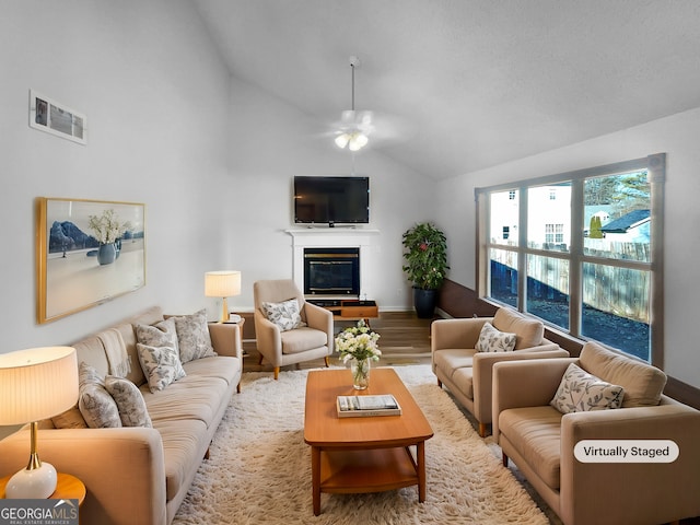 living room with hardwood / wood-style flooring, lofted ceiling, and ceiling fan