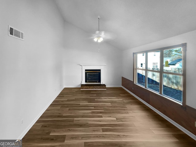 unfurnished living room featuring dark wood-type flooring, ceiling fan, and lofted ceiling