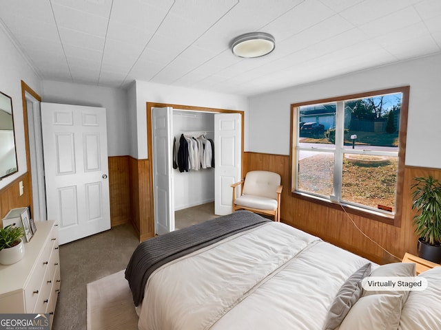 carpeted bedroom with wooden walls and a closet