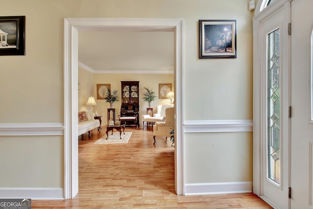 foyer entrance featuring crown molding and light wood-type flooring