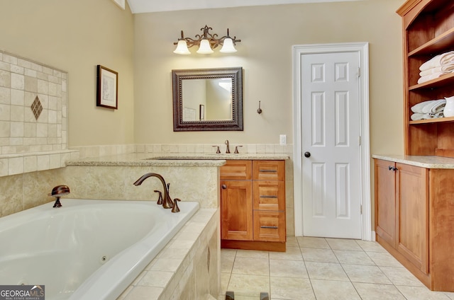 bathroom with tiled tub, vanity, and tile patterned floors