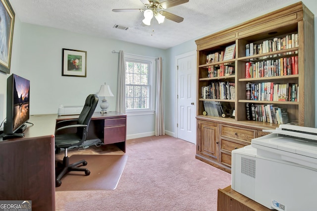 carpeted office space with ceiling fan and a textured ceiling