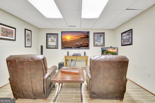 living area featuring a paneled ceiling