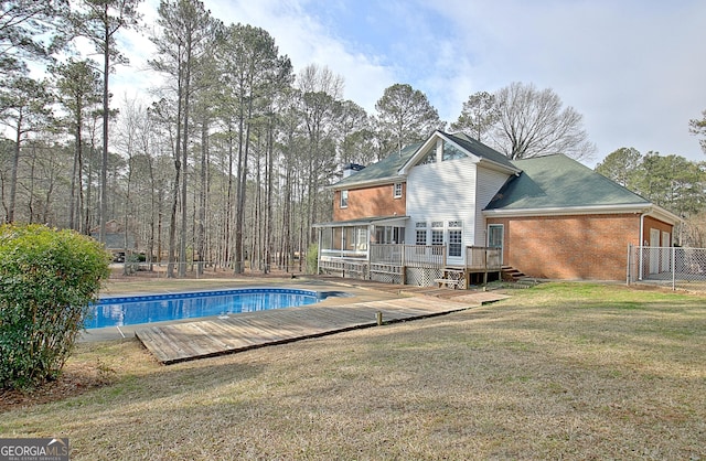 view of pool featuring a wooden deck and a lawn