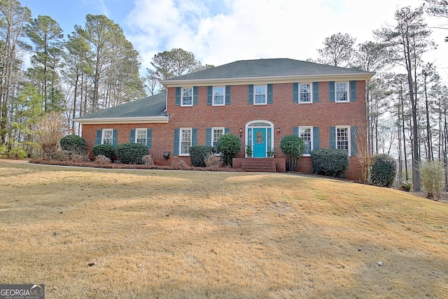 colonial home featuring a front lawn