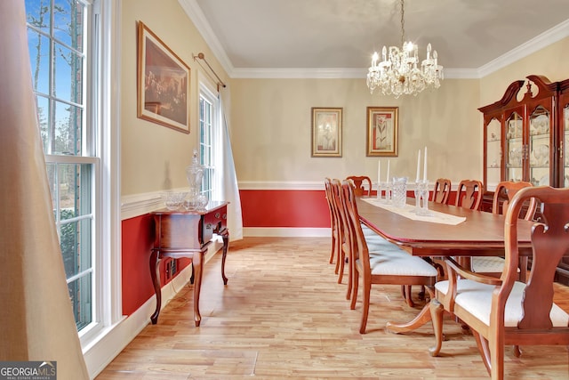 dining room with plenty of natural light, ornamental molding, a chandelier, and light wood-type flooring