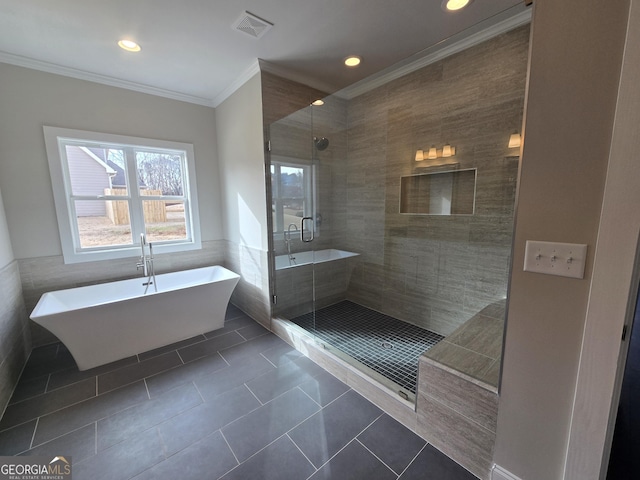 bathroom featuring crown molding, separate shower and tub, tile walls, and tile patterned floors