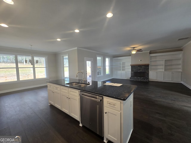 kitchen with pendant lighting, white cabinetry, sink, stainless steel dishwasher, and a center island with sink