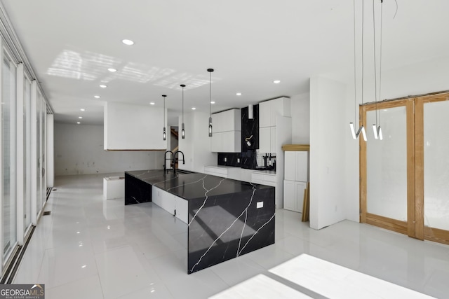 kitchen with pendant lighting, a large island, sink, and white cabinets