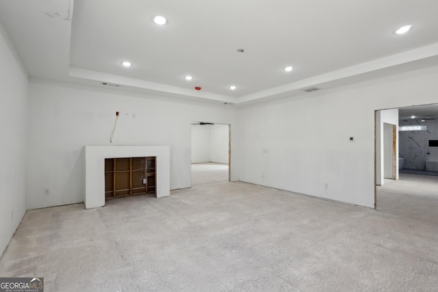 unfurnished living room with a raised ceiling