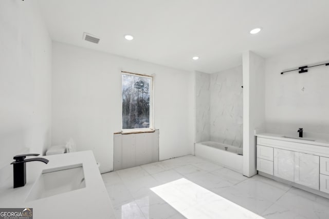 bathroom featuring vanity and a bath