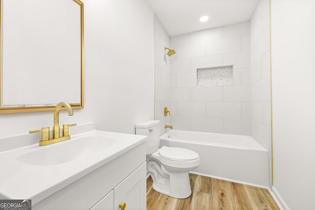 full bathroom featuring vanity, hardwood / wood-style flooring, toilet, and tiled shower / bath