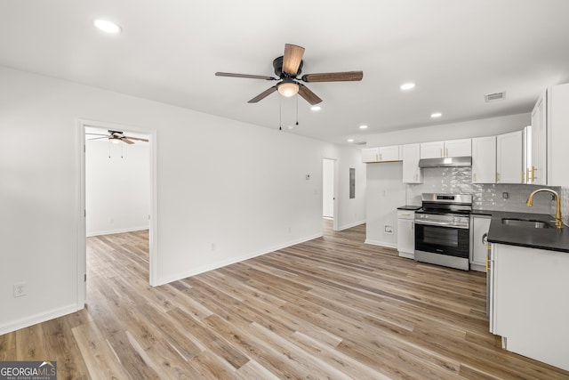 kitchen with electric stove, sink, light hardwood / wood-style flooring, backsplash, and white cabinets