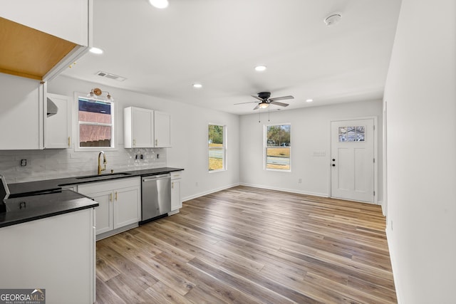 kitchen featuring sink, tasteful backsplash, light hardwood / wood-style flooring, dishwasher, and white cabinets