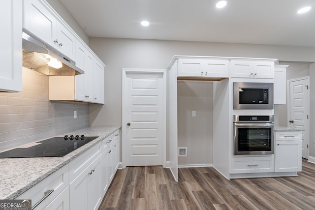 kitchen with built in microwave, black electric stovetop, light stone countertops, and stainless steel oven