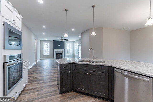 kitchen featuring appliances with stainless steel finishes, sink, hanging light fixtures, and white cabinets