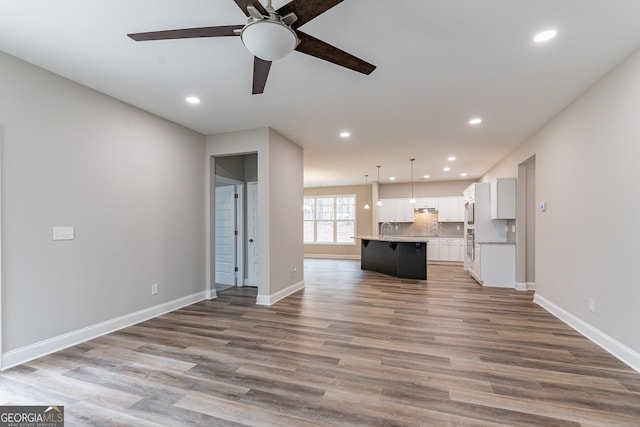 unfurnished living room featuring ceiling fan and light hardwood / wood-style floors