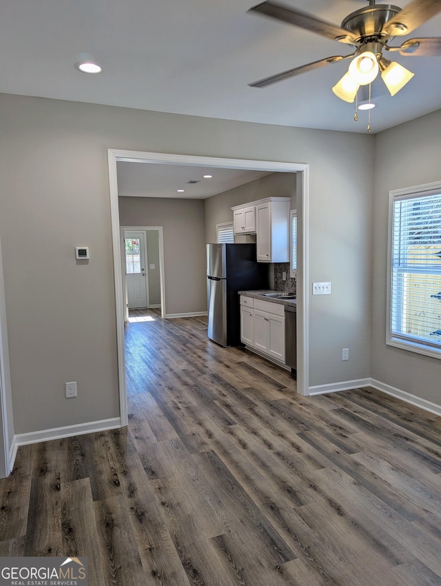 kitchen with white cabinetry, appliances with stainless steel finishes, dark wood-type flooring, and a wealth of natural light