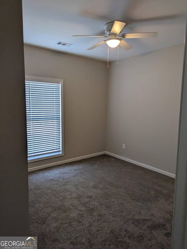 spare room featuring ceiling fan and carpet