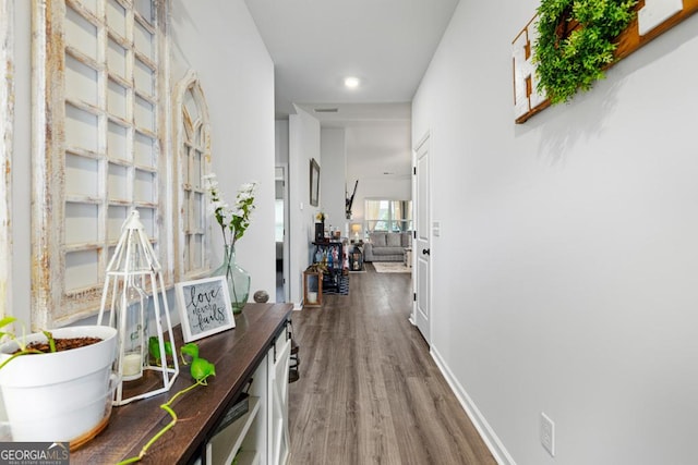 corridor featuring baseboards and wood finished floors