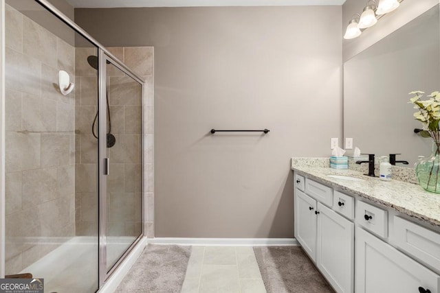 full bathroom with tile patterned flooring, a stall shower, vanity, and baseboards