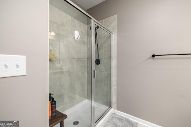 full bathroom featuring a shower stall and baseboards