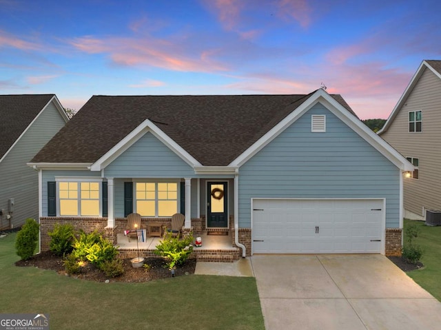 craftsman-style home featuring a garage, a lawn, and a porch