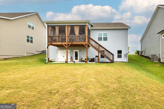 rear view of property with a yard, a sunroom, stairs, and a patio area