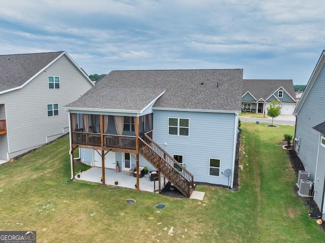 rear view of property with a sunroom, a lawn, central air condition unit, and a patio area