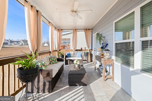 sunroom / solarium featuring ceiling fan