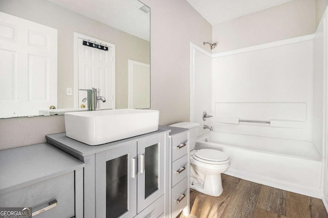 full bathroom featuring vanity, wood-type flooring, toilet, and shower / tub combination