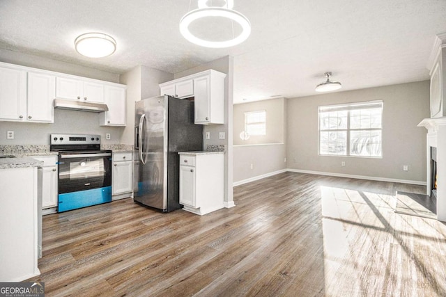 kitchen featuring pendant lighting, white cabinetry, stainless steel appliances, light stone counters, and light wood-type flooring