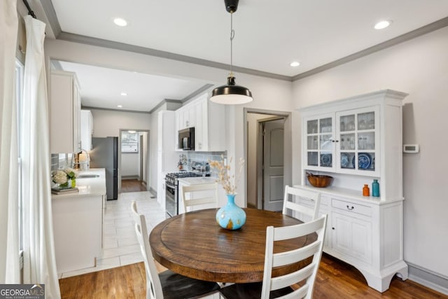 dining space with crown molding and wood-type flooring