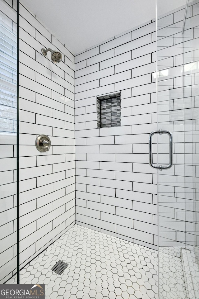 bathroom with a shower with door