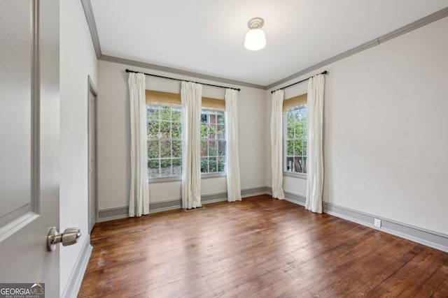 empty room featuring ornamental molding and hardwood / wood-style floors