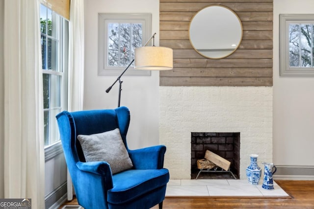 living area featuring hardwood / wood-style flooring and a brick fireplace