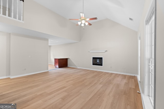 unfurnished living room featuring ceiling fan, high vaulted ceiling, and light wood-type flooring