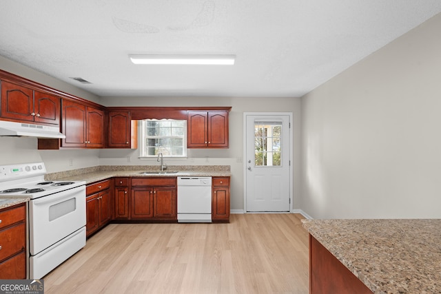 kitchen featuring sink, white appliances, light stone counters, light hardwood / wood-style floors, and a textured ceiling